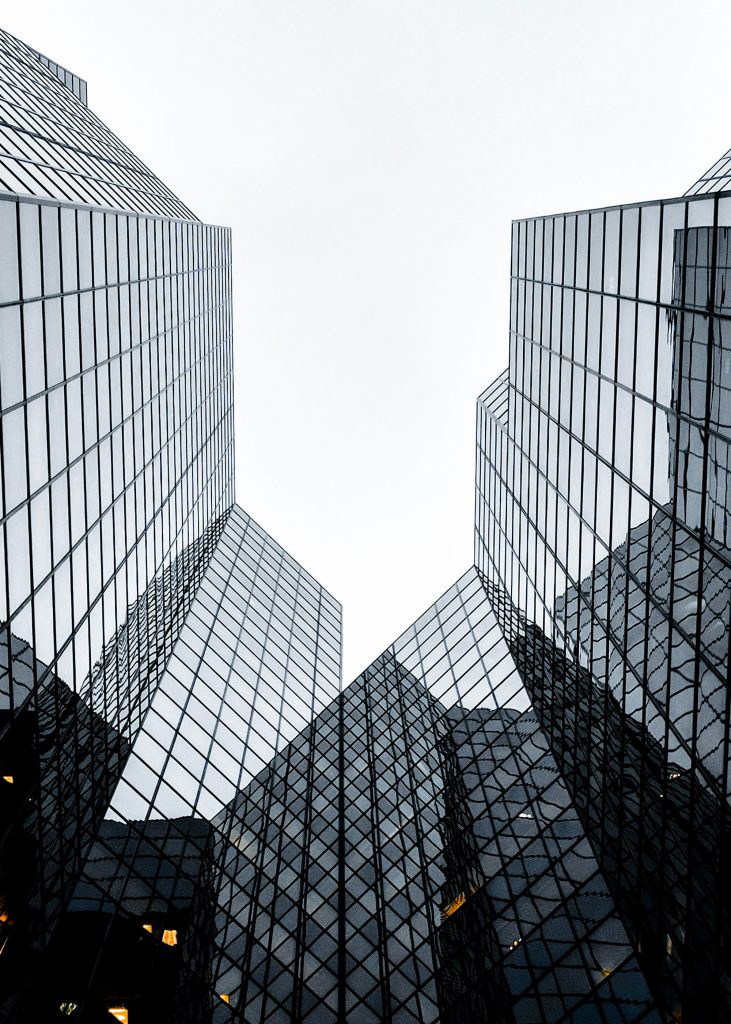Tall glass buildings converging upwards.